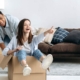 Happy mixed race young family couple, bought their own house, they having fun on moving day