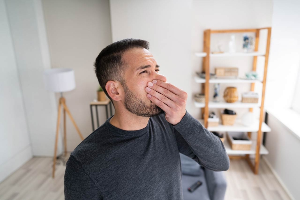 Man holding hi nose from a bad smell from an air conditioner