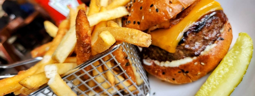 Close-up of a delicious all beef cheeseburger with melted cheese and assorted toppings