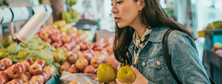 A young female traveler buying fruits in the original farmers market