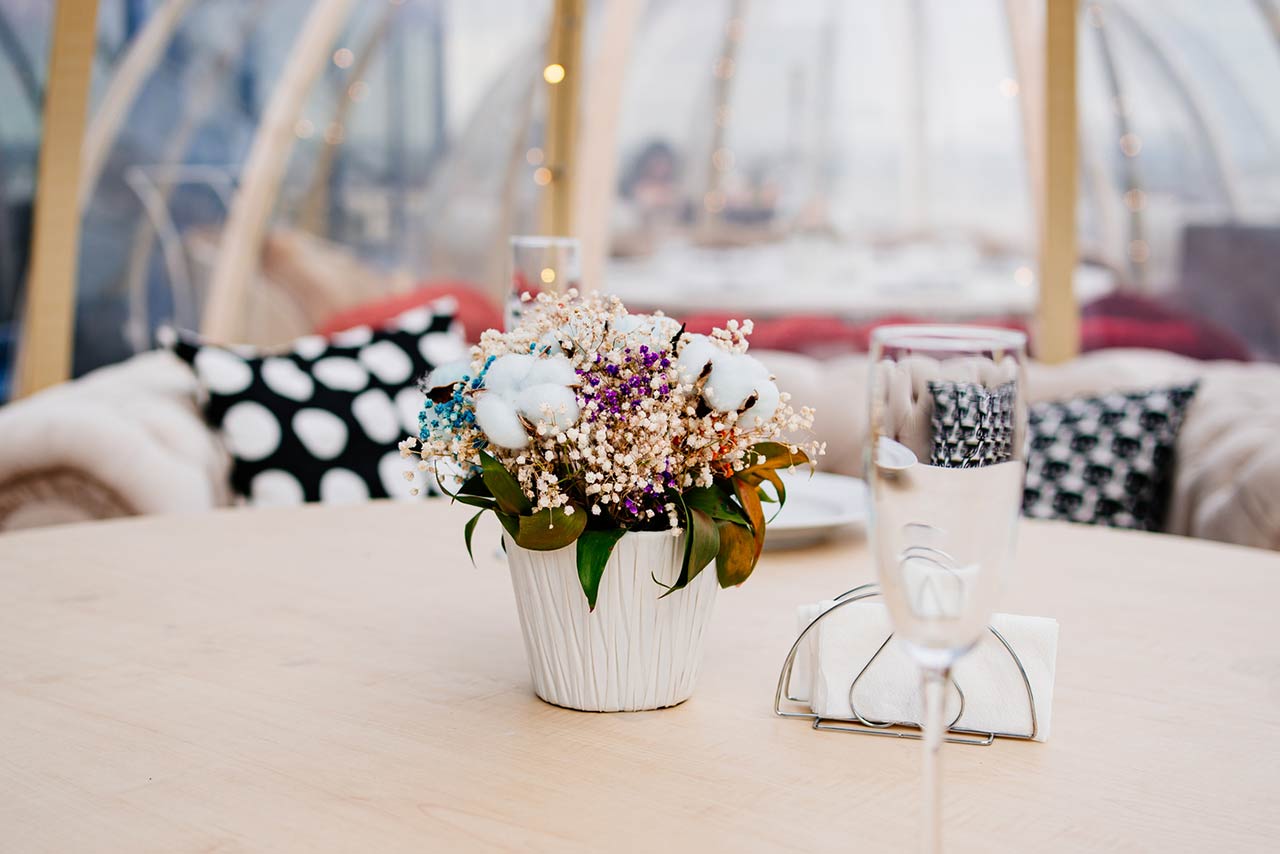 Plate in the foreground on a table in a cafe in the form of an igloo