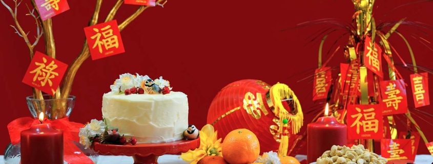 Chinese New Year party table in red and gold theme with food and traditional decorations